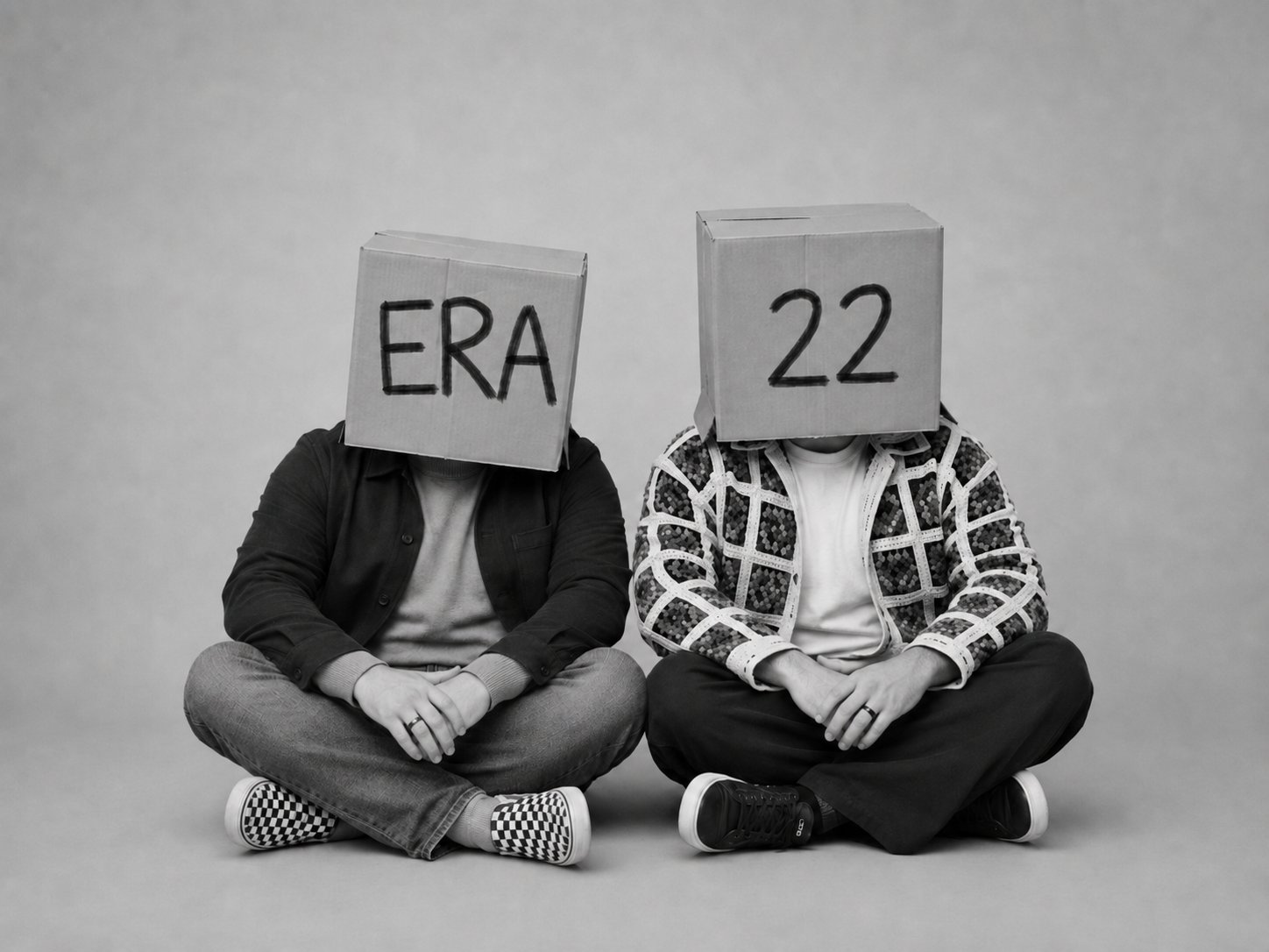 Daniel and Roy seated with boxes labelled ERA and 22.